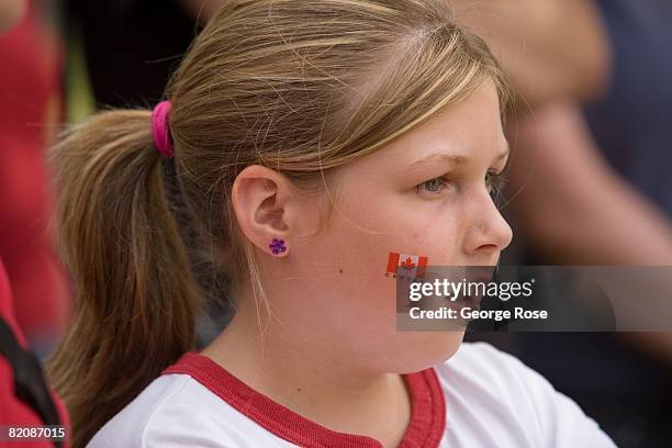 Young girl with a Canadian maple leaf flag sticker on her cheek waits for the Canada Day festivities to begin in this 2008 Penticton, British...