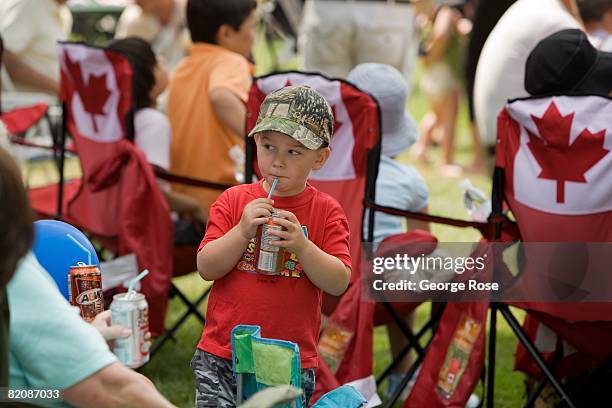 Young boy sips soda from a can during Canada Day festivities in this 2008 Penticton, British Columbia, Canada, summer photo. Canada Day is the...