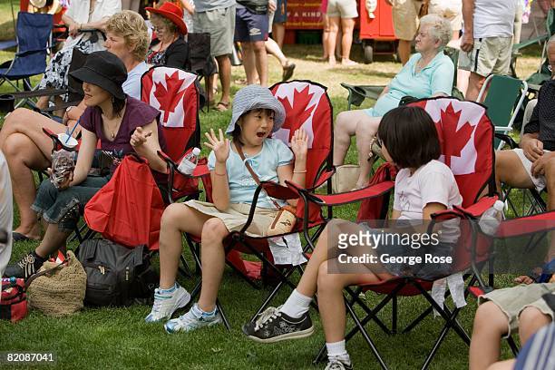 Kids seated in Canadian maple leaf flag chairs wait for the Canada Day festivities to begin in this 2008 Penticton, British Columbia, Canada, summer...