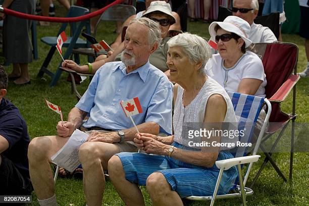 An elderly couple wave the Canadian maple leaf flag during Canada Day festivities in this 2008 Penticton, British Columbia, Canada, summer photo....