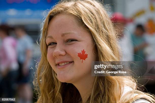 Young girl with a Canadian maple leaf flag sticker on her cheek waits for the Canada Day festivities to begin in this 2008 Penticton, British...