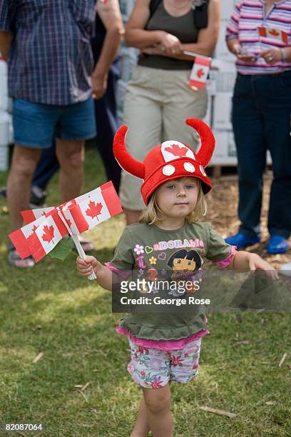 Young girl waves the Canadian maple leaf flag during Canada Day festivities in this 2008 Penticton, British Columbia, Canada, summer photo. Canada...