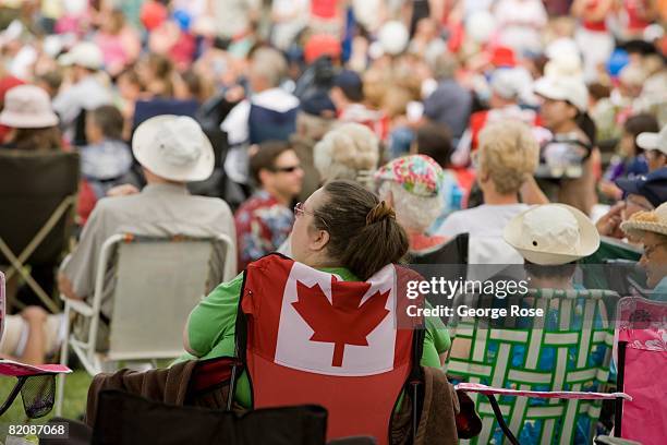 Spectator seated in Canadian maple leaf flag chair waits for the Canada Day festivities to begin in this 2008 Penticton, British Columbia, Canada,...