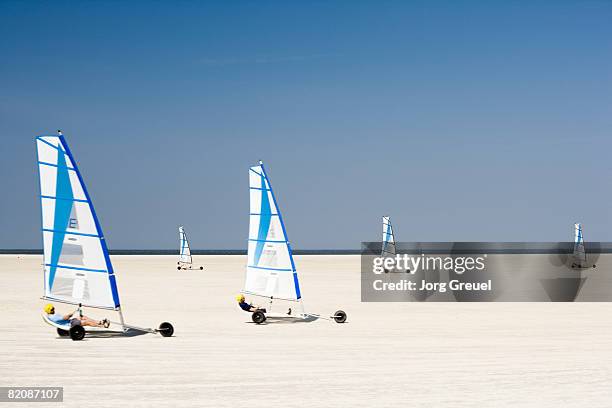 sand yachting on beach - zeilwagen stockfoto's en -beelden