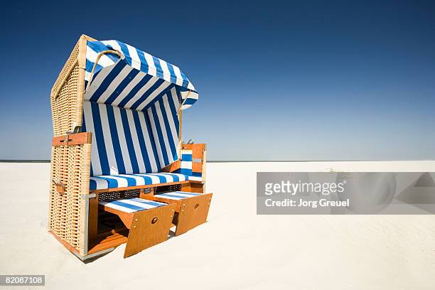 wicker beach chair on beach - strandkorb stockfoto's en -beelden