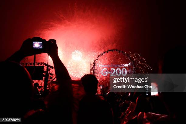 People watch fireworks during the ceremony marking the 200 days to go to the PyeongChang Winter Olympic Games on July 22, 2017 in Chuncheon, South...