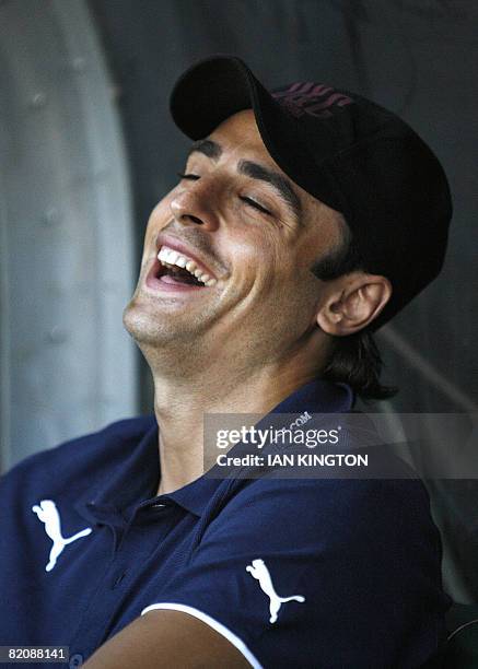 Tottenham's Bulgarian footballer Dimitar Berbatov laughs as he chats with assistant Clive Allen before kick off and starts as substitute during the...