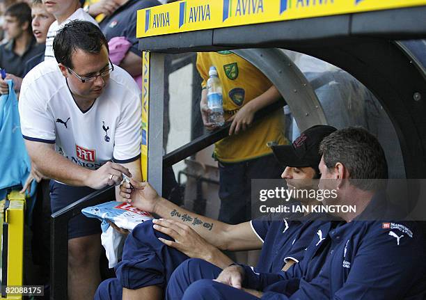 Tottenham's Bulgarian footballer Dimitar Berbatov signs an autograph as he chats with assistant Clive Allen before kick off and starts as substitute...