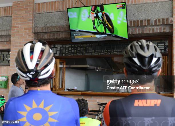 Cyclists follow the 104th edition of the Tour de France cycling on a screen in Llanogrande, a municipality near Medellin, Colombia, on July 22, 2017....