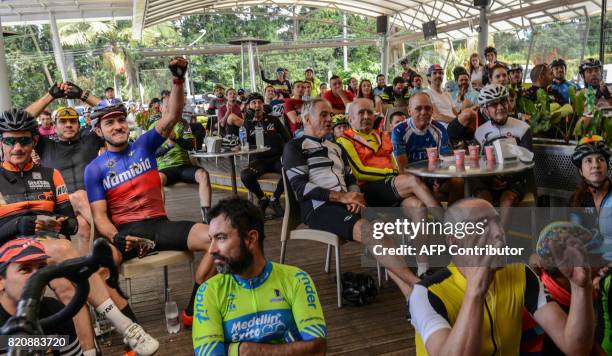 Cyclists follow the 104th edition of the Tour de France cycling on a screen in Llanogrande, a municipality near Medellin, Colombia, on July 22, 2017....