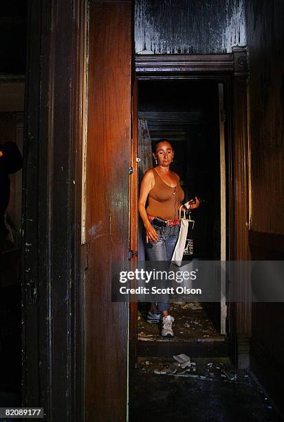 Luce Torrez looks over damage at the home of her cousin, Maria Rolon, the day after a fire in the house killed one of Rolon's sons and critically...