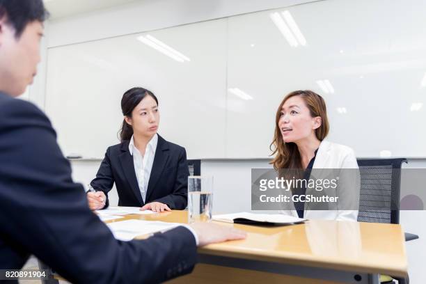 female business executives taking the interview of a potential employee - boss over shoulder stock pictures, royalty-free photos & images