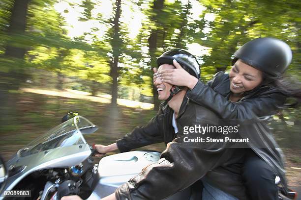 woman covering boyfriend's eyes while driving - steve prezant stock pictures, royalty-free photos & images