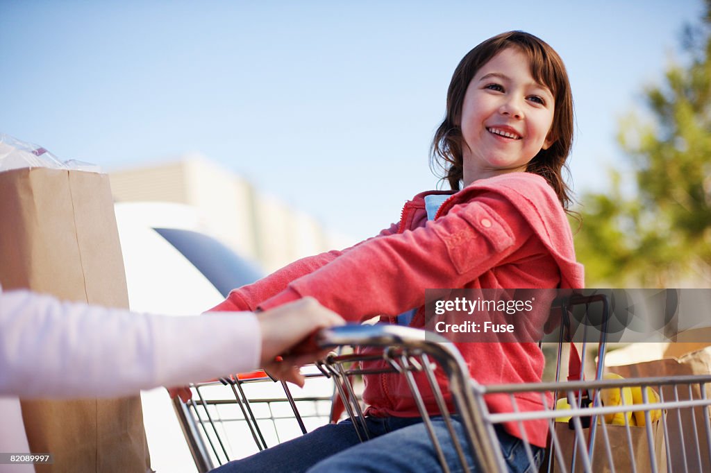 Mother Pushing Daughter in Shopping Cart
