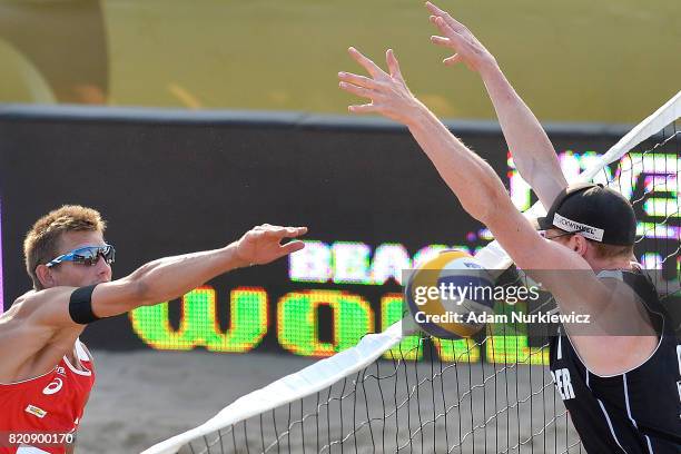 Latvia's Haralds Regza attacks against Germany's Lars Fluggen while men's semifinal during FIVB Grand Tour - Olsztyn: Day 4 on July 22, 2017 in...