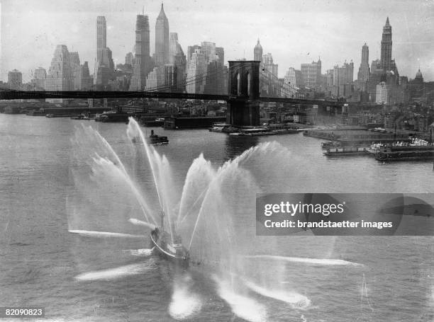 Ship of the fire-brigade of New York at the daily exercise, In background the Brooklyn Bridge and the Skyline of New York, America, Photograph, June...