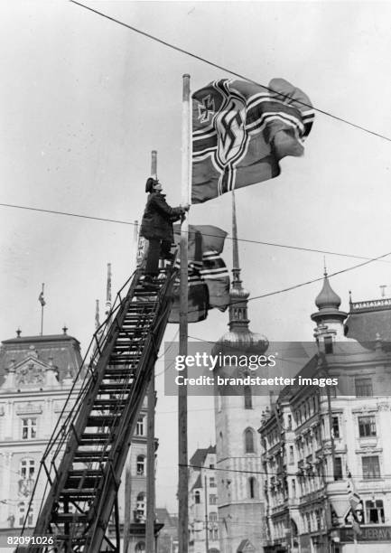 Ceremonial flying of the Reichskriegsflagge at Adolf-Hitler-Square in Brno, Photograph, 1939 [Feierliche Flaggenhissung der Reichskriegsflagge auf...