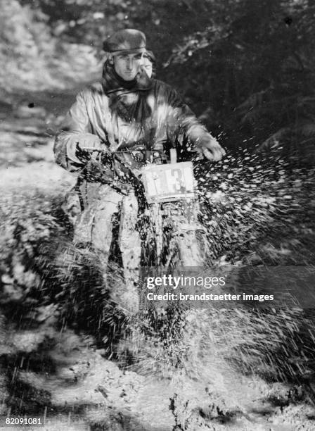 Motorcycle driving through mud at a race of the Carshalton Motor Cycling Club, Photograph, October 6th 1935 [Motorradfahrer durchquert ein...