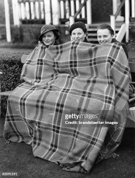 Three women wraped in a warming blanket, Photograph, Around 1930 [Drei Frauen in eine w?rmende Decke eingewickelt, Photographie, Um 1930]
