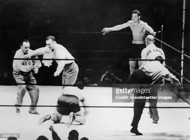 The referee is counting the seconds at the heavy weight boxing match for the title of the world champion between Joe Louis and Max Schmeling , New...