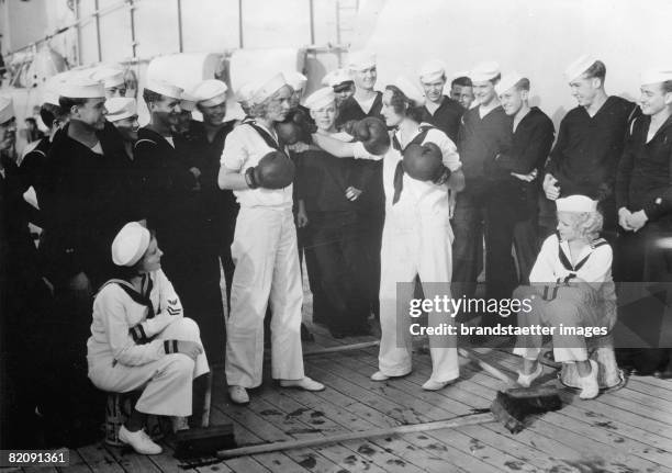 Women boxing on board of a amercian war-ship for a man that they both love, Photograph, Around 1930 [Frauen-Boxen an Bord eines amerikanischen...