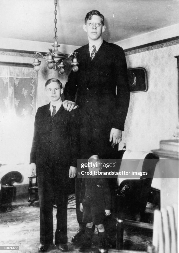 The american Robert Wadlow, who is the tallest man in medicine history, at his 17th birthday with his brothers, Photograph, America, Around 1930