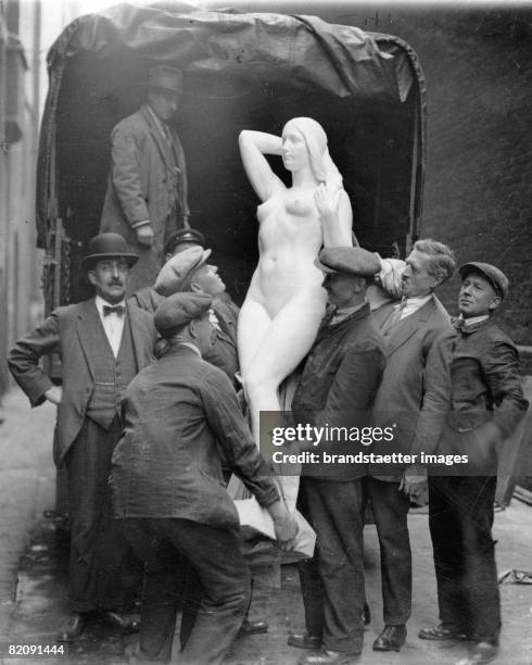 Workers lifting a sculpture of a woman from a lorry, The sculpture is one of 18,000 works which were handed in for the acceptance of the Royal...