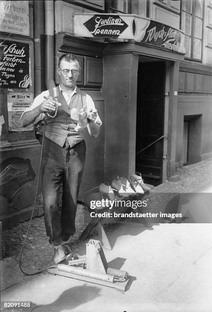 Within one minute old shoos can be colored with a special spraying method, Photograph, Around 1935 [Innerhalb einer Minute k?nnen alte Schuhe mittels...