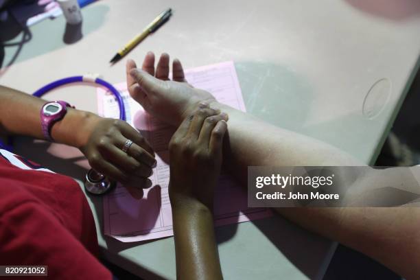 Nurse takes the pulse of a patient at a free health clinic on July 22, 2017 in Wise, Virginia. Appalachia residents received free medical, dental and...