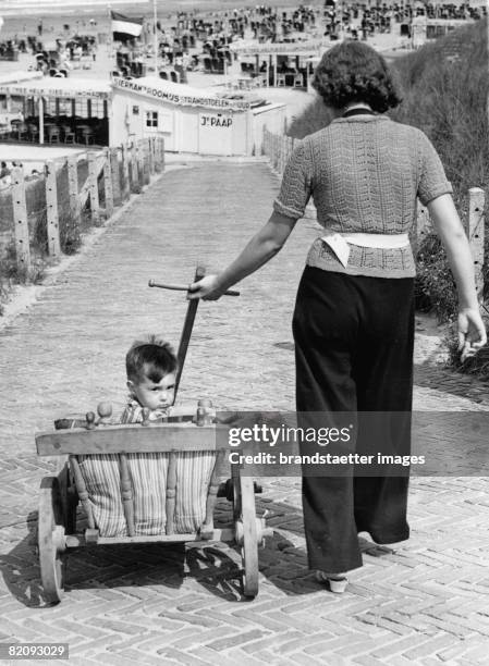 Dutch mother transporting her baby to the beach at the Dutch holiday resort Zandvoort, Photograph, 1937 [Eine niederl?ndische Mutter bringt ihr Baby...