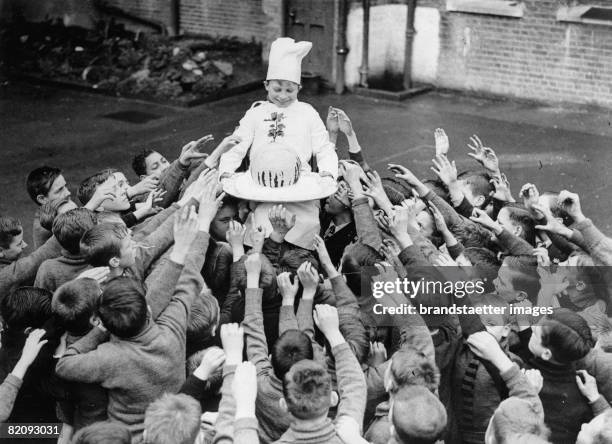 Boys of a Dr, Barnados Home in England get a Christmas Pudding, Photograph, England, December 1937 [Buben in einer sozialen Einrichtung in England...