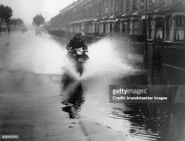 Motorcyclist in fooded street in London, Photograph, England, August 23rd 1935 [Ein Motorradfahrer in einer ?berfluteten Strasse in London,...