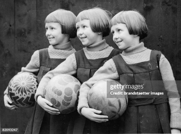 To avoid confusions of these triplets their initials were sewed on their chlothes, Also their playballs have different patterns, Photograph, England,...