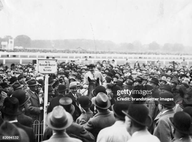 The winning horse of the austrian derby in Vienna-Freudenau is beeing brought to a scale, Photograph, 1936 [Das Siegerpferd des ?sterreichischen...