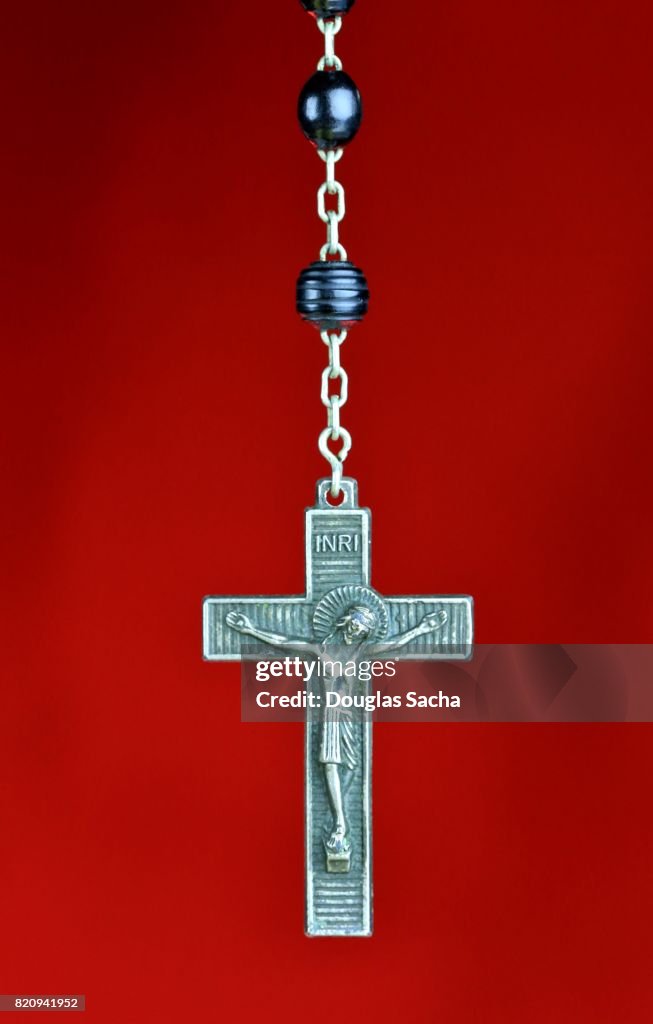 Religious Rosary praying beads on a red background