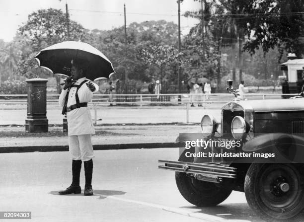 Traffic policeman in Kalkutta with a sunshade, Photograpg, Around 1935 [Verkehrspolizist in Kalkutta mit Sonnenschirm, Photographie, Um 1935]