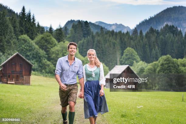 couple in traditional lederhosen and dirndl tracht, austria - roupa tradicional imagens e fotografias de stock