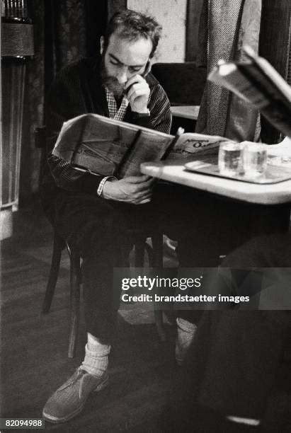 Austrian artist Friedensreich Hundertwasser in Cafe Hawelka in Vienna reading the newspaper, Photograph, Around 1956 [Maler Friedensreich...
