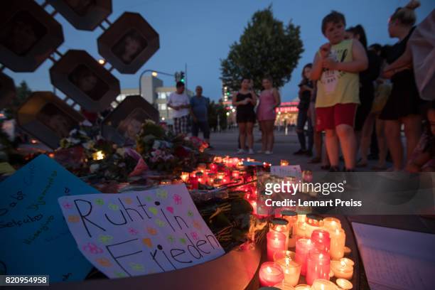 Mourners gather at a memorial to commemorate the victims of the shooting spree that one year ago left ten people dead, including the shooter, on July...