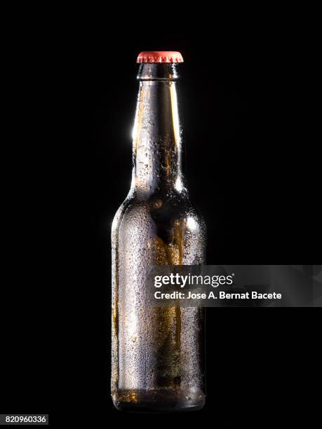 bottle of beer with the glass esmerilado with drops of water and a steam cloud frozen on a black bottom - beer mat stockfoto's en -beelden