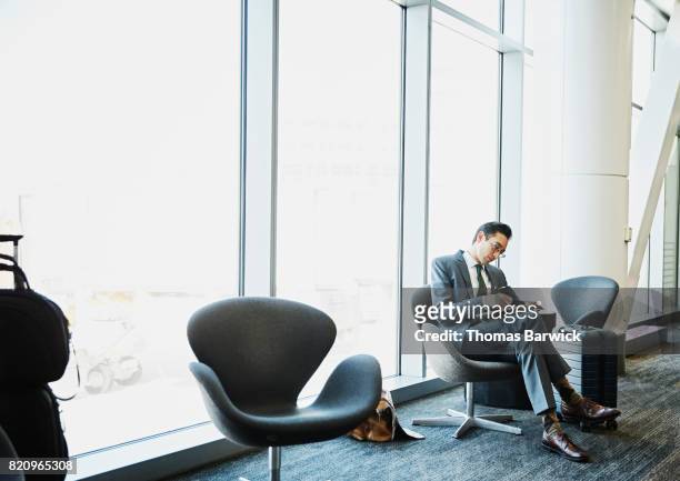 businessman taking notes while waiting for flight in airport - airport departure area stock pictures, royalty-free photos & images