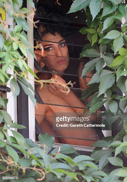 Singer Amy Winehouse sits looking out the window of her North London home on June 11, 2008 in London, England. Amy Winehouse was admitted to...