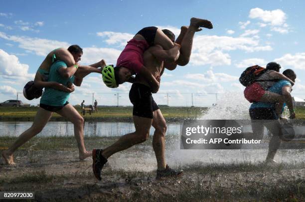 People take part in a wife-carrying championship during Viva Braslaw festival in the town of Braslaw, some 250 km north of Minsk on July 22, 2017. /...