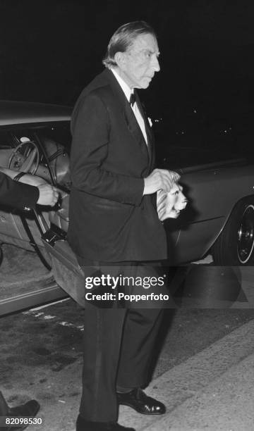 American industrialist billionaire J. Paul Getty arrives at London Zoo for a fancy dress party carrying a lion mask, 13th July 1972. The party is...