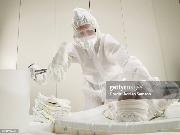 mother changing baby - funny surgical masks stockfoto's en -beelden