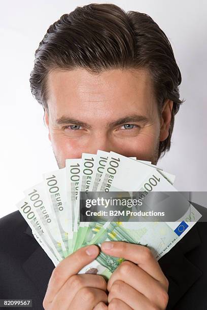 portrait of young man with euro banknotes - greed stock pictures, royalty-free photos & images