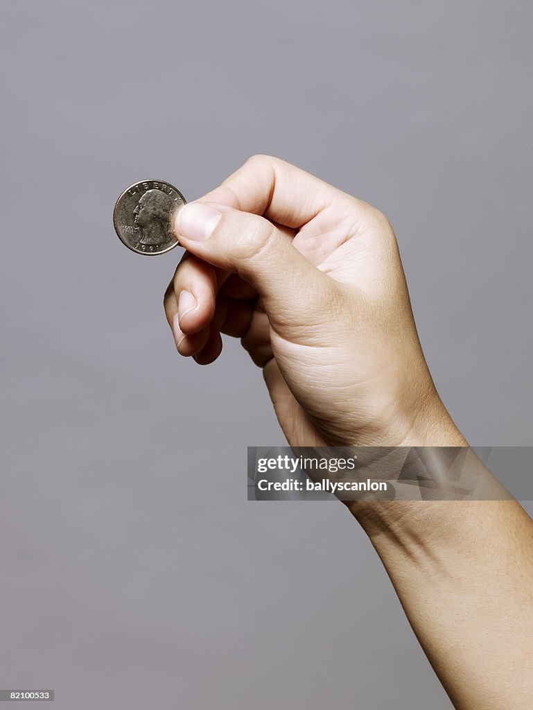 Hand holding a quarter (25 cents)