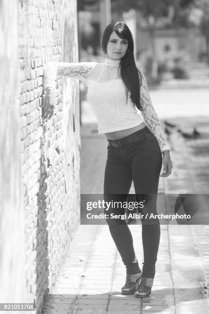 elegant woman leaning against a wall in a valencia street. - sergi albir stock pictures, royalty-free photos & images