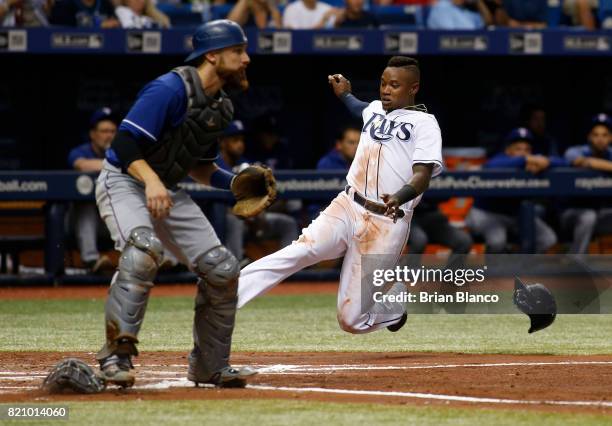 Tim Beckham of the Tampa Bay Rays beats catcher Jonathan Lucroy of the Texas Rangers to home plate to score off of an RBI single by Steven Souza Jr....