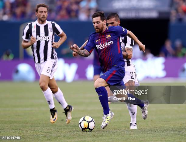 Lionel Messi of Barcelona heads for the goal as Stefano Sturaro and Claudio Marchisio of Juventus defend in the first half during the International...